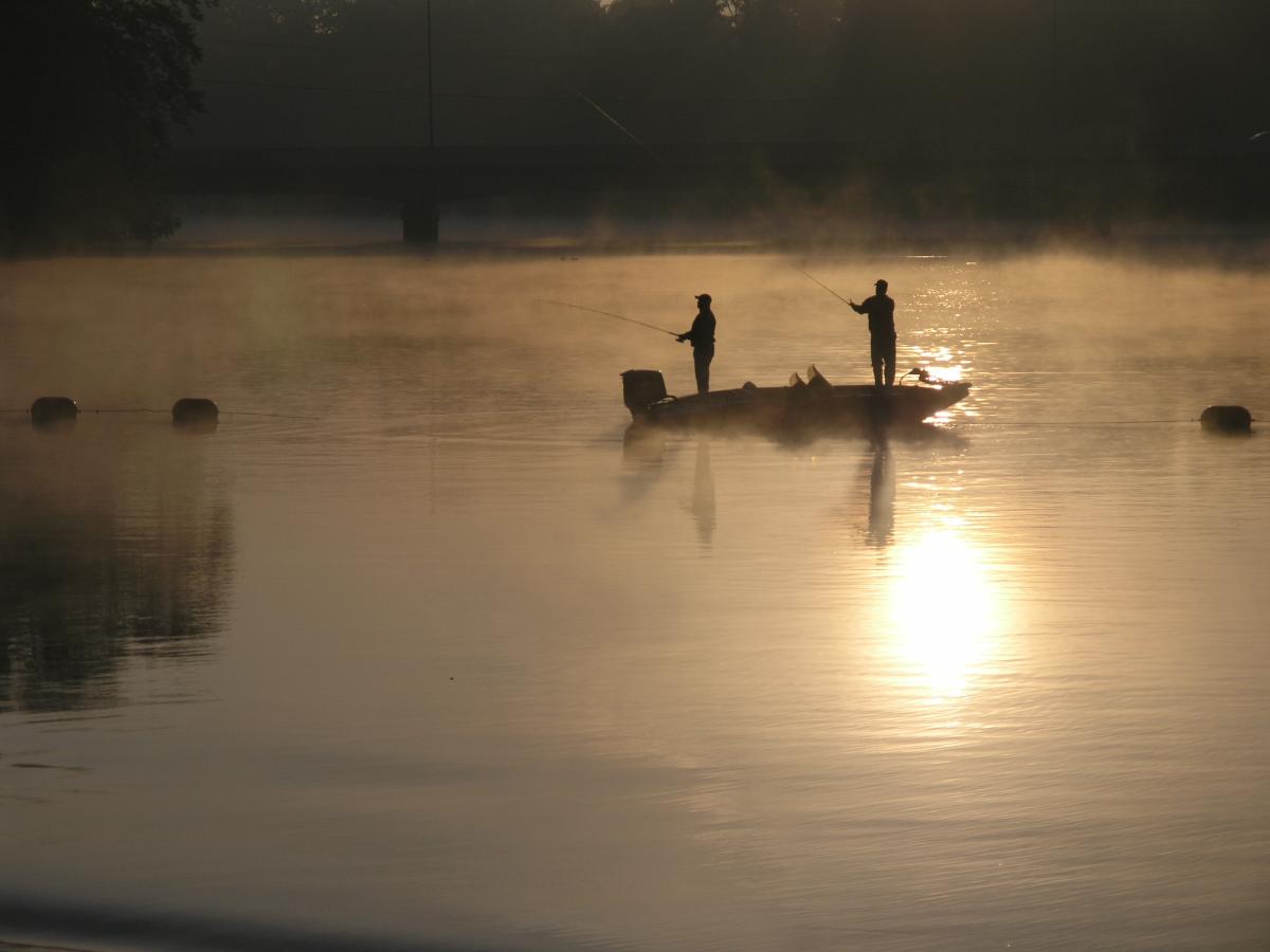 Photo of the St. Joseph River with a boat and anglers silhouetted
